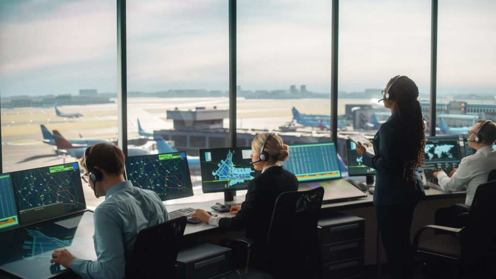 air traffic control team working at a modern control console in an airport tower